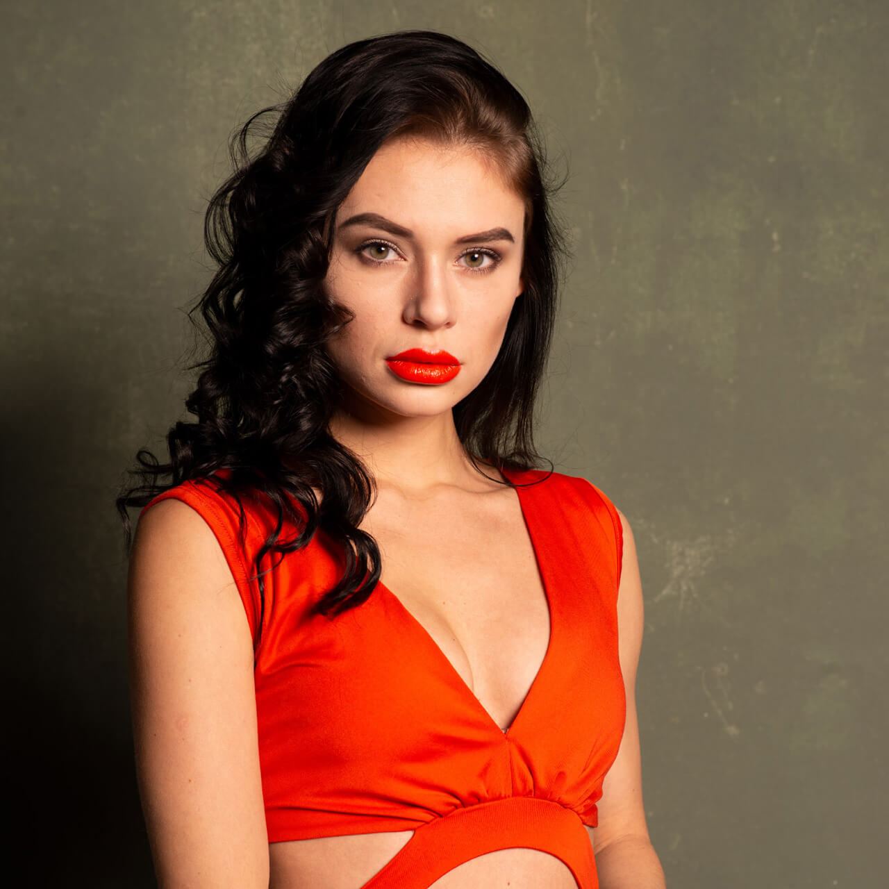 Before: Portrait of a dark-haired woman with red lipstick in a red top