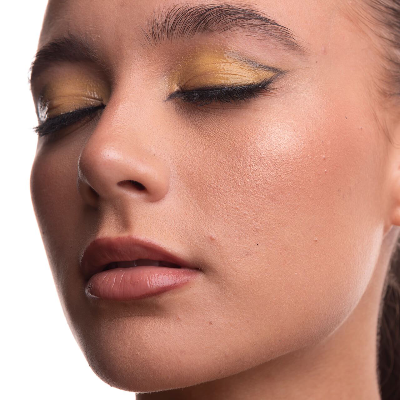 Before: Close-up of a woman’s face with yellow eyeshadow and winged eyeliner