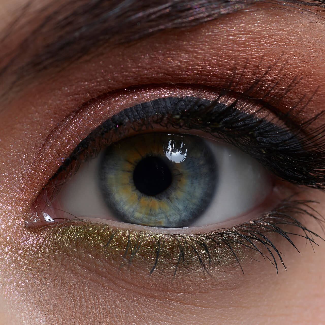After: Extreme close-up of an eye with golden-green glitter eyeshadow